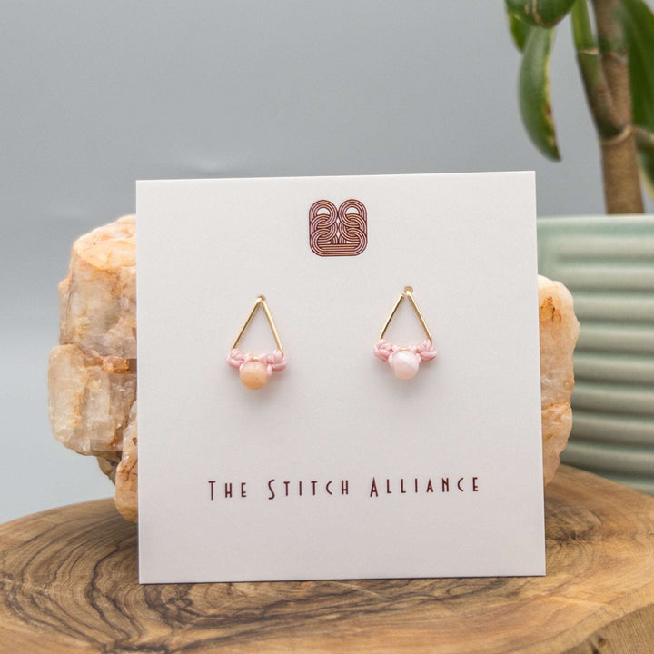 14k gold filled triangle shaped post-style earrings with a 4mm pink opal bead on a white background
