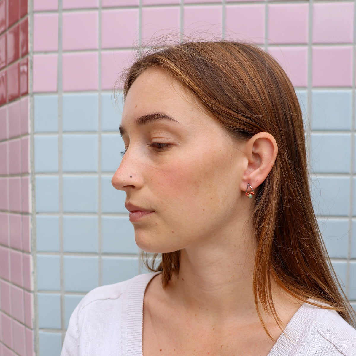 small triangle macrame earrings with oxidized sterling silver metal and aqua terra jasper bead worn on a model