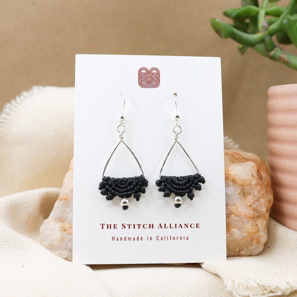 sterling silver triangle hoop earrings with black macrame half moon on white card