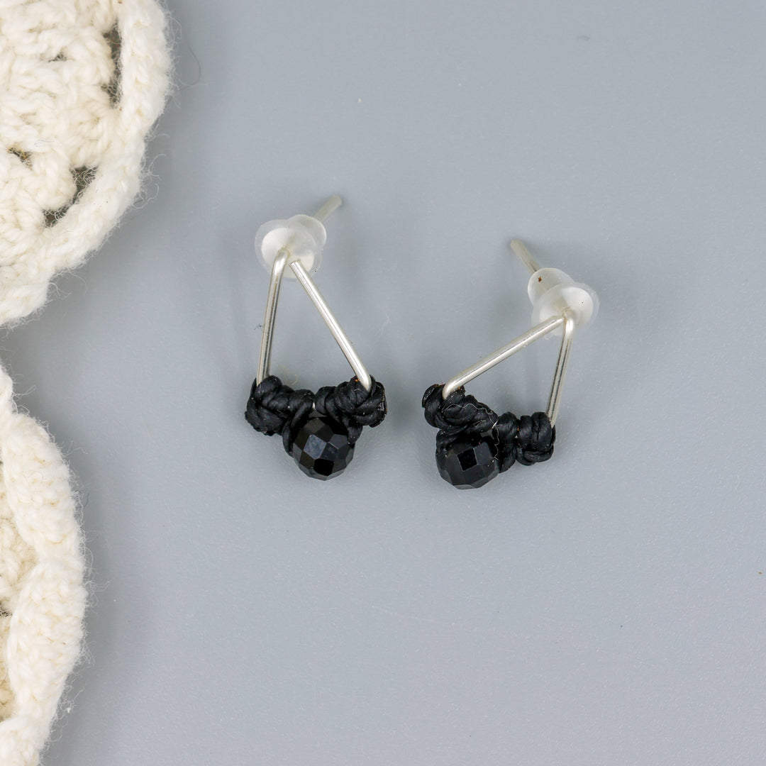 handmade triangle stud earrings sterling silver with black spinel beads overhead view
