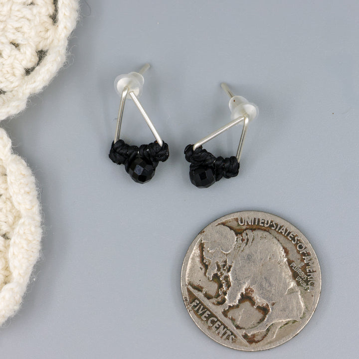 handmade triangle stud earrings sterling silver with black spinel beads with a nickel for size comparison