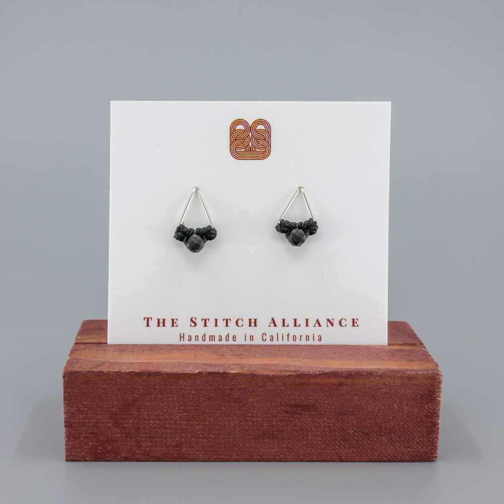handmade triangle stud earrings sterling silver with black spinel beads on a white display card