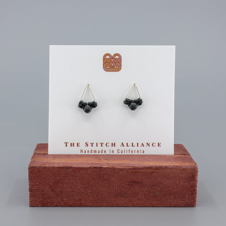 handmade triangle stud earrings sterling silver with black spinel beads on a white display card