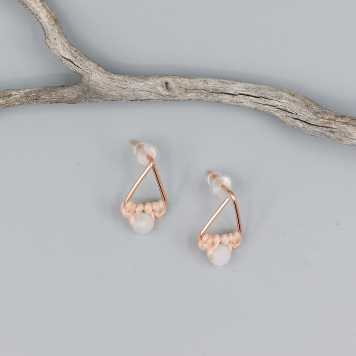 rose gold triangle earrings with moonstone bead on gray background