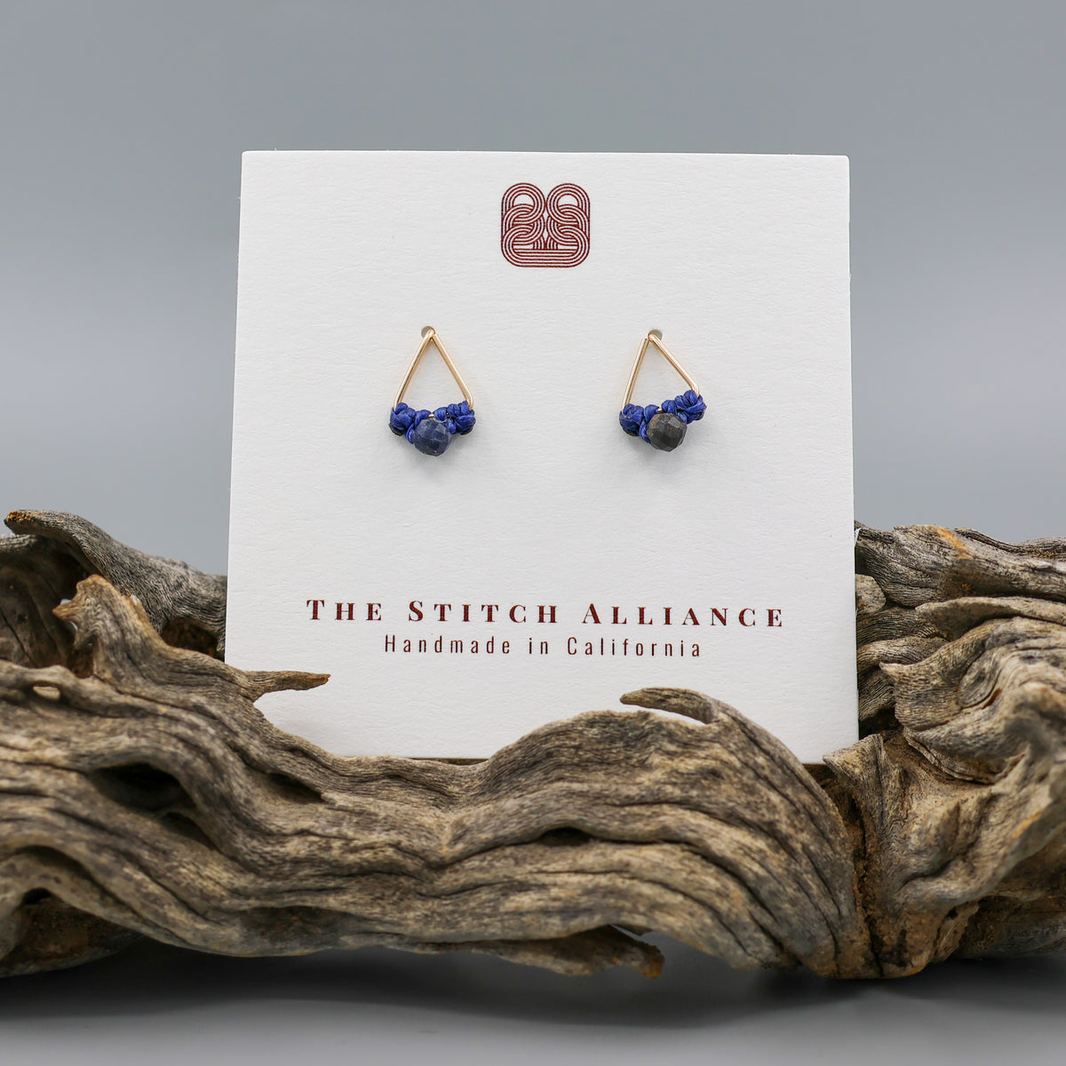 handmade gold filled triangle stud earrings with sapphire beads  on a white card
