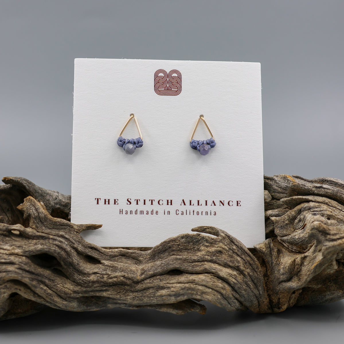 handmade gold filled triangle stud earrings with tanzanite beads on a white card