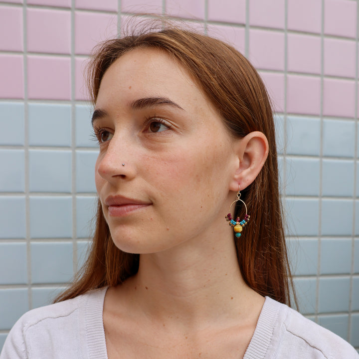 gold macrame hoop earrings with golden tiger's eye beads worn on a model