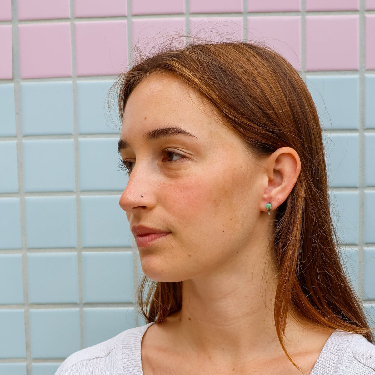 turquoise stud earrings worn on a model