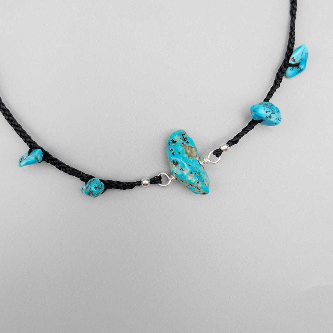 close up of a turquoise choker necklace using vintage Kingman turquoise beads on a black plated cord and finished with sterling silver. 