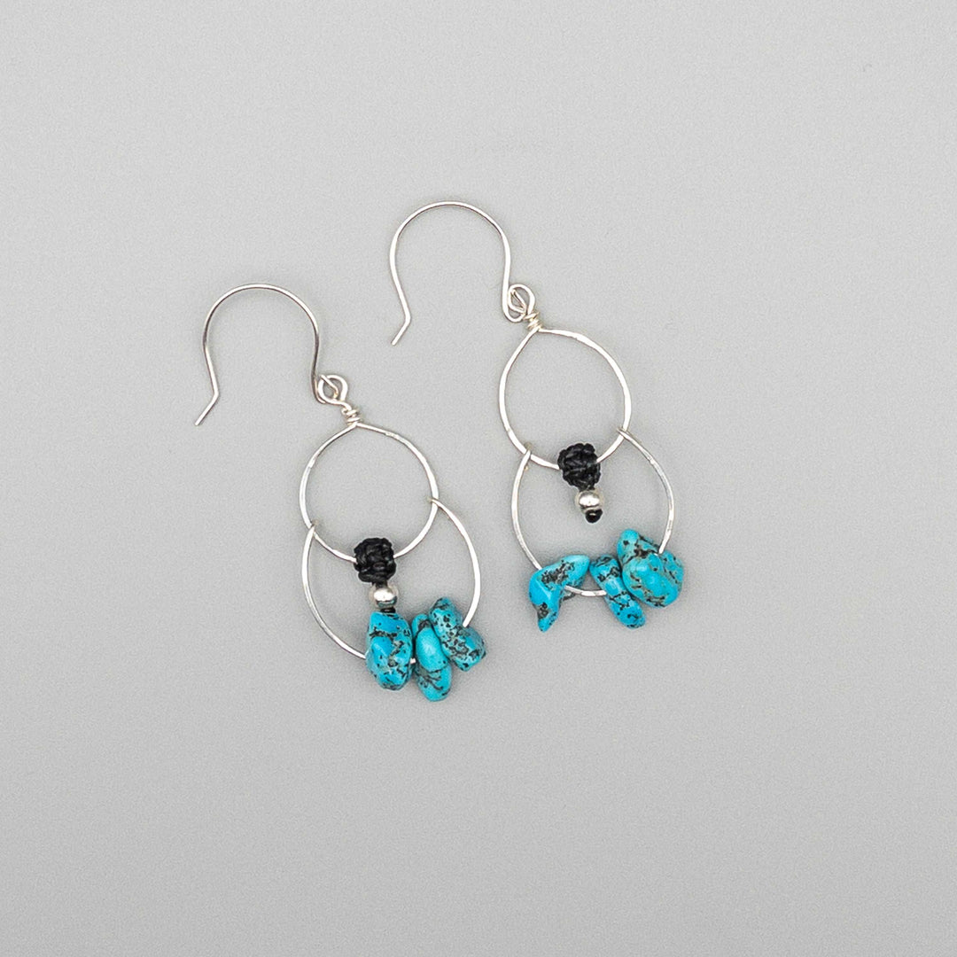 Double hoop sterling silver earrings with turquoise beads flat on gray background
