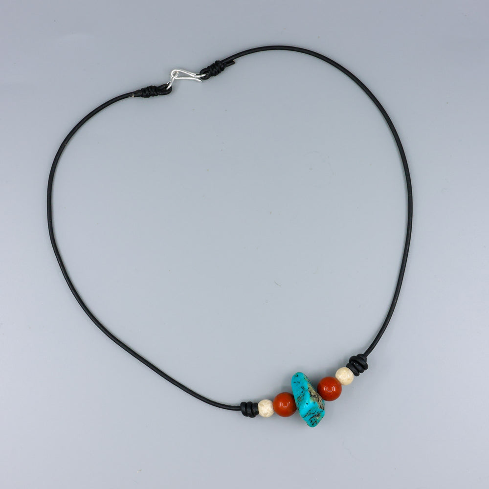 handmade turquoise, red jasper, and riverstone leather choker with sterling silver hook clasp on gray background