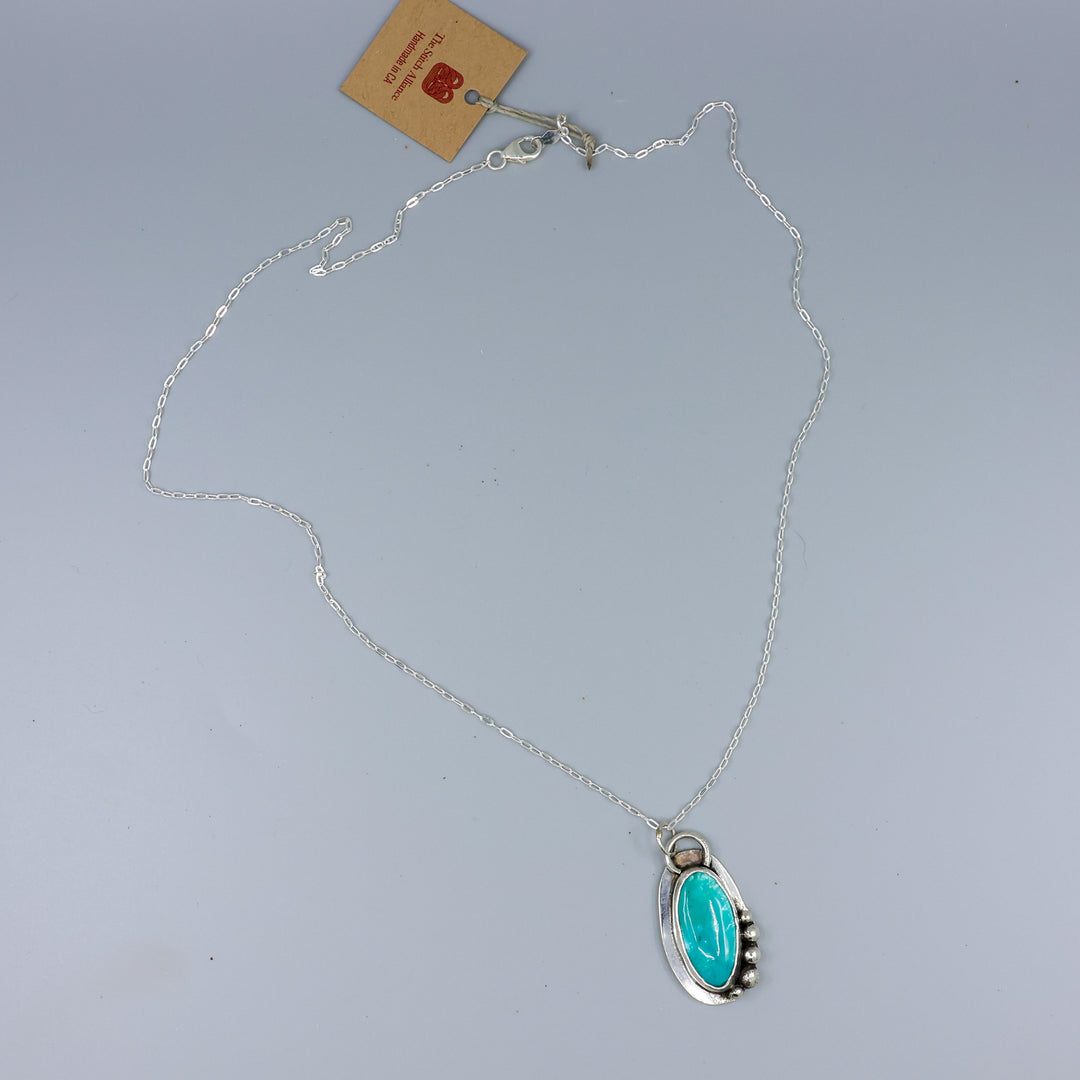 handmade turquoise necklace sterling silver on a gray background