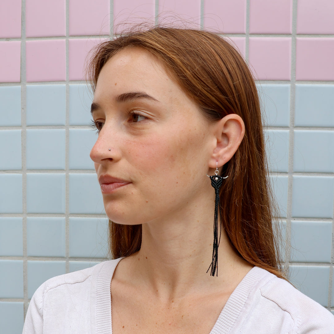 black macrame statement earrings worn on a model
