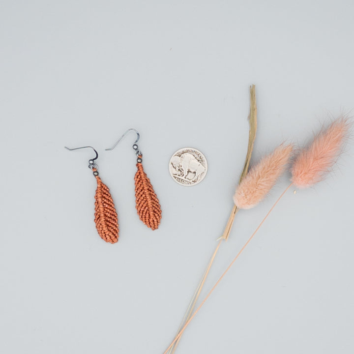 Earthy terracotta macrame feather earrings with oxidized sterling silver ear wires on gray background