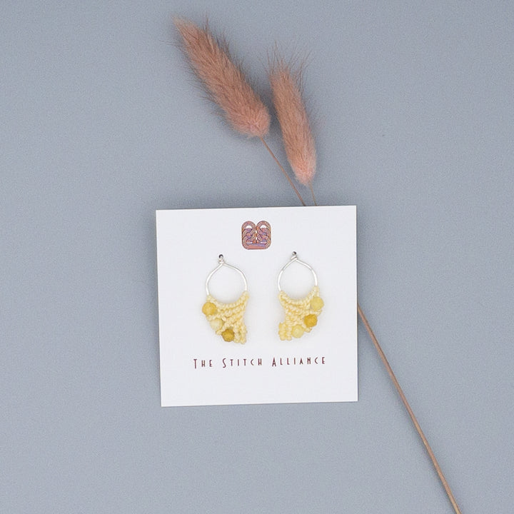 sterling silver and yellow opal macrame earrings on gray background