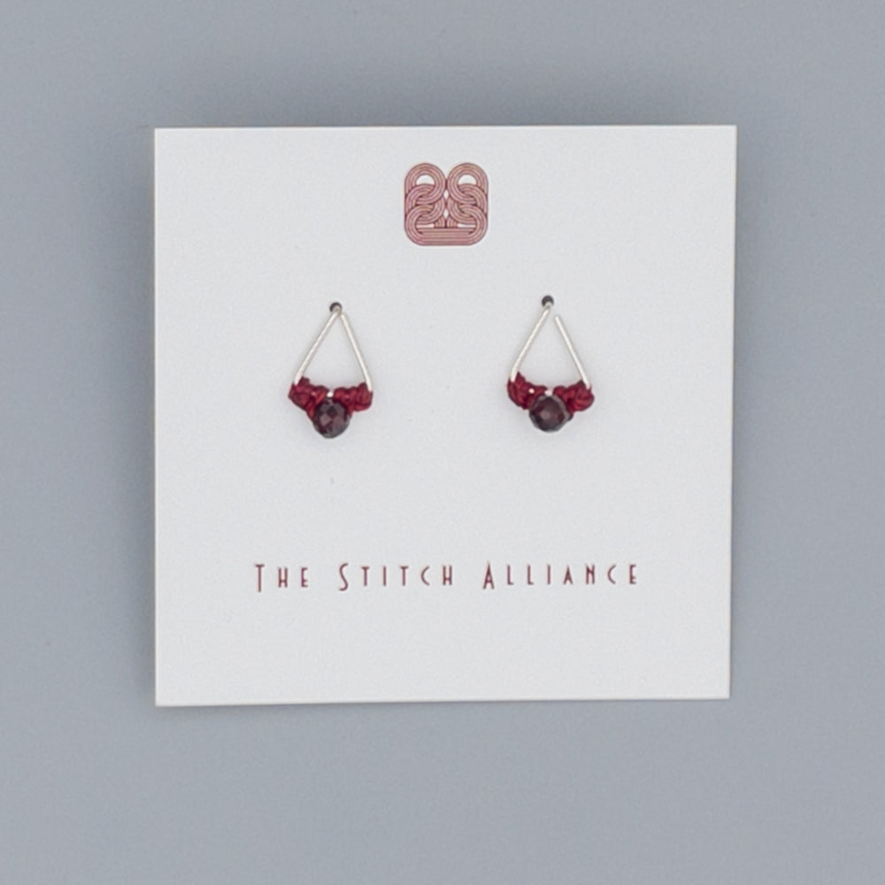 close up of Sterling silver triangle post earrings with garnet beads
